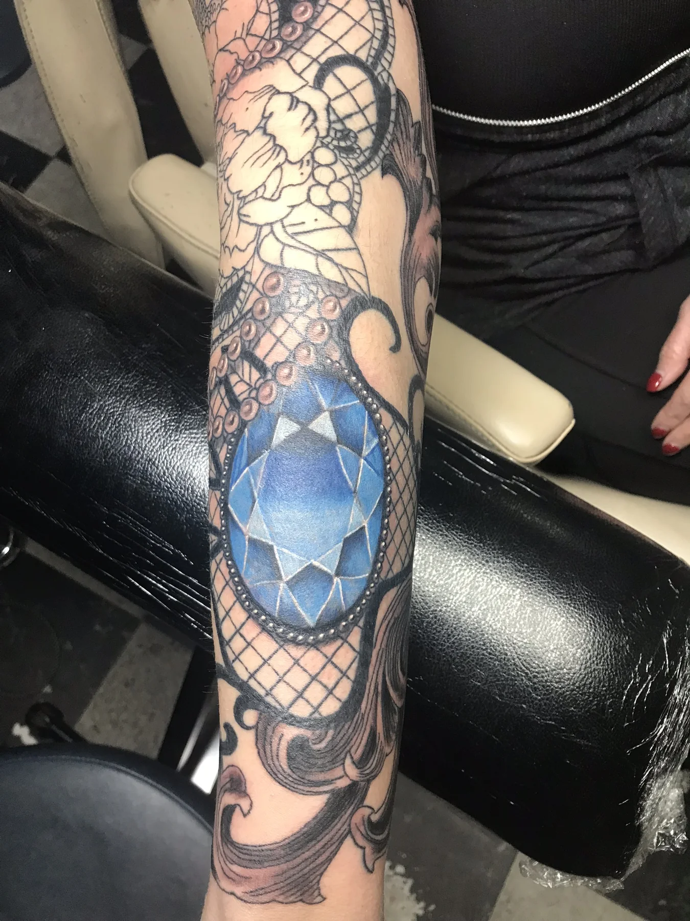 Blue gemstone and ornamental color sleeve tattoo by Josh Poindexter