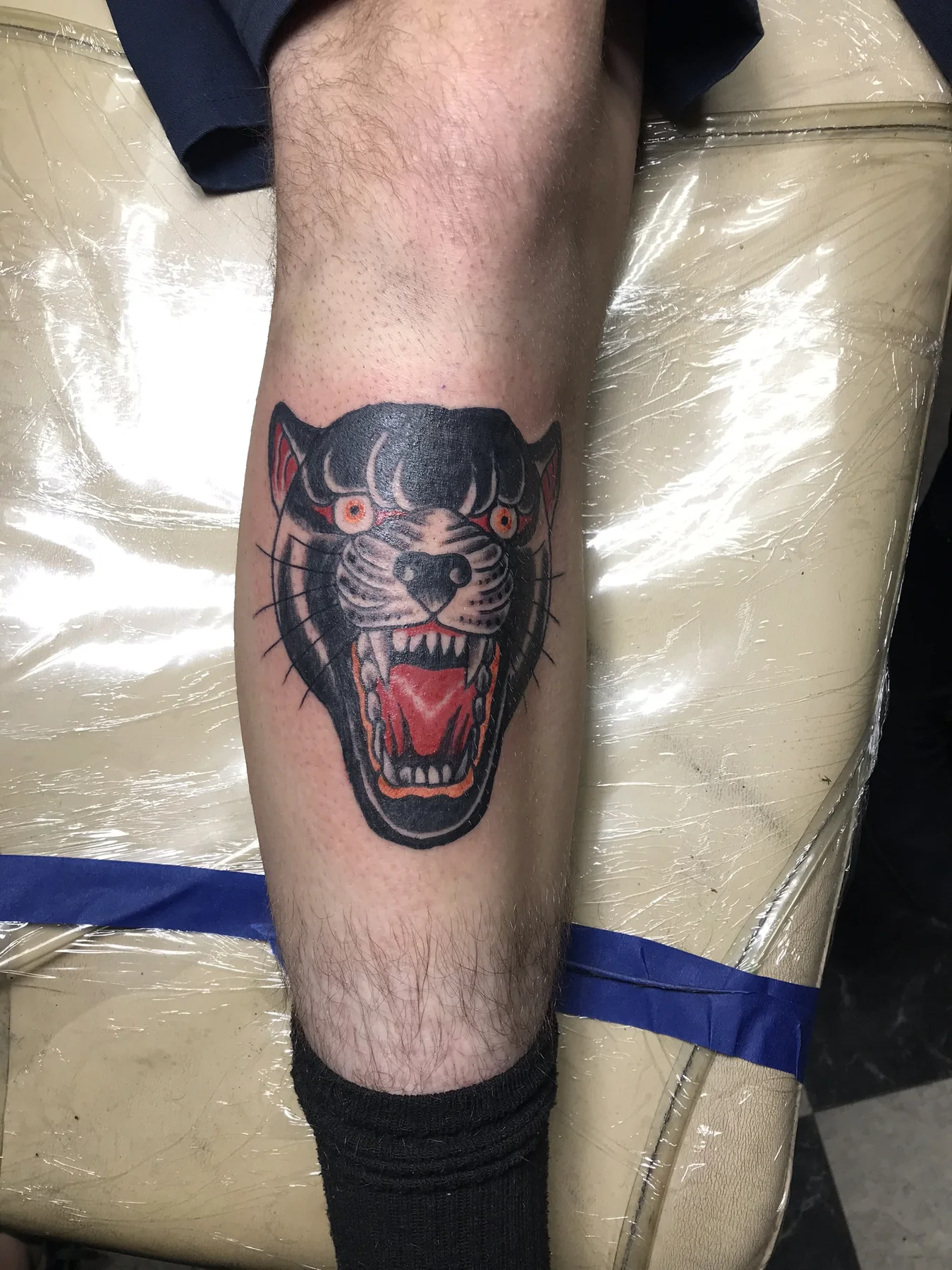 Bold black and red traditional panther tattoo by Josh Poindexter