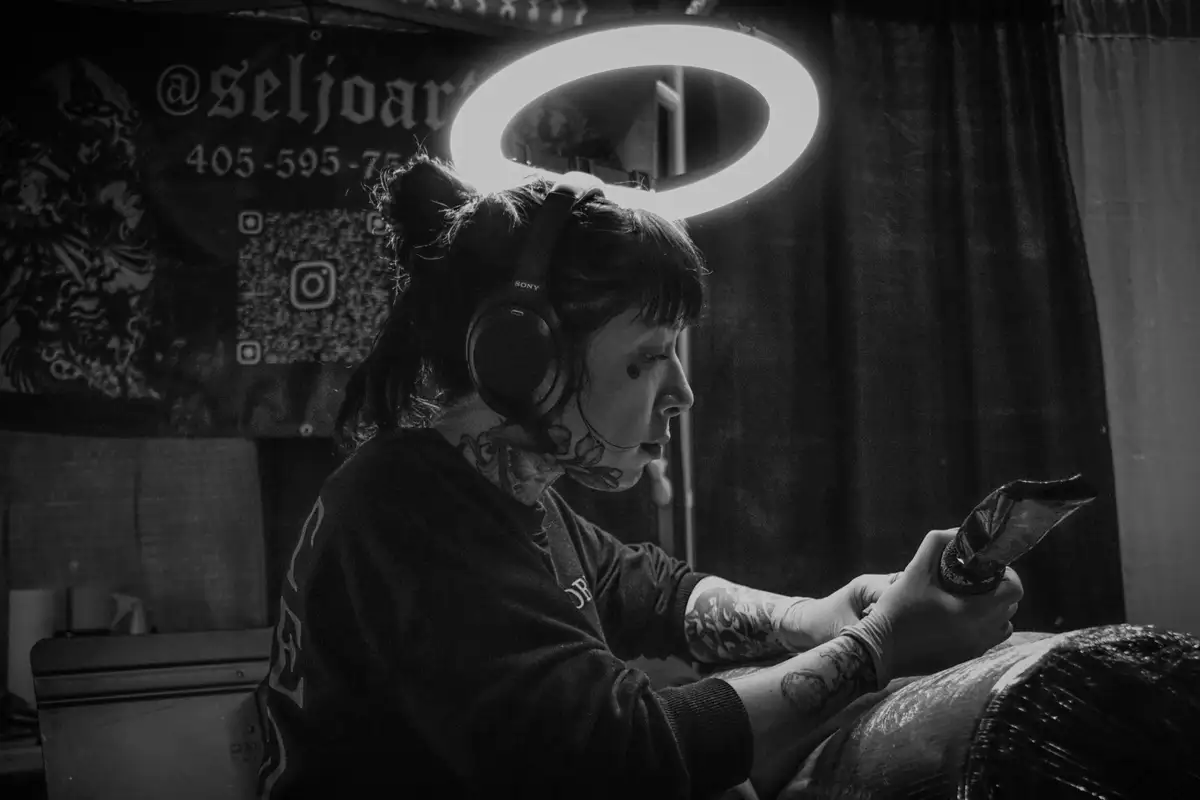 Selena Gjovaag tattooing a client under a ring light at Tornado Tattoo in Oklahoma City